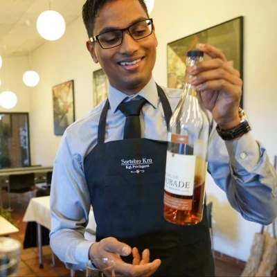 Elev på tjeneruddannelsen fortæller om vinen til maden, hvilket er en del af undervisningen