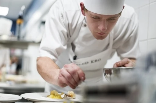 Elev på gastronom uddannelsen er fordybet i at lave mad og anretter den helt sirligt