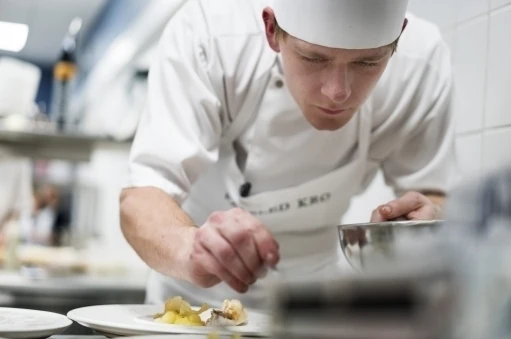 Elev på gastronom uddannelsen er fordybet i at lave mad og anretter den helt sirligt